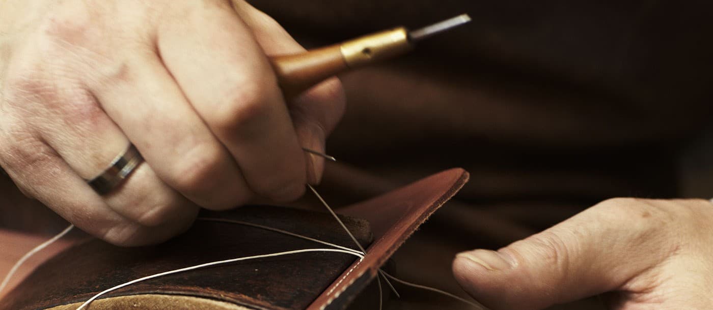 Close-up of a luxury leather handbag detail, highlighting craftsmanship, texture, and stitching.